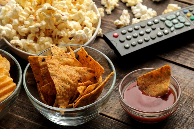 Tortilla and popcorn, TV remote on a brown wooden background. concept of watching movies at home. close-up.