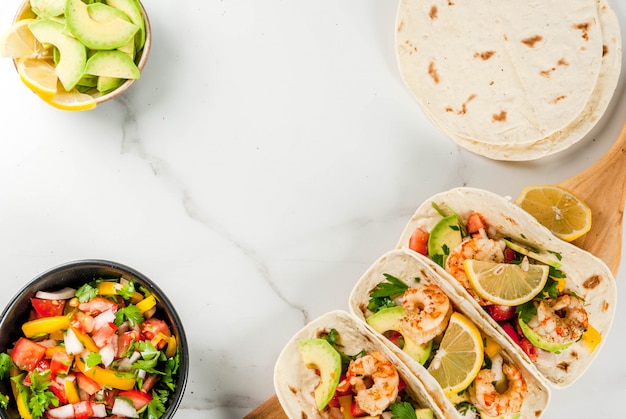 Tortilla-taco's met traditionele huisgemaakte salade, peterselie, verse citroen, avocado en gegrilde garnalen