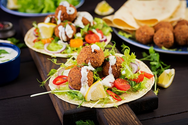 Tortilla wrap with falafel and fresh salad. Vegan tacos. Vegetarian healthy food.