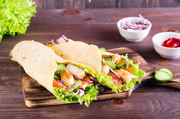 Tortilla wraps with chicken cucumber and tomato on a board on the table Mexican cuisine