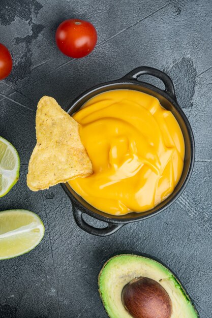 Tortillachips met kaasdipsaus, op grijze tafel, bovenaanzicht of plat