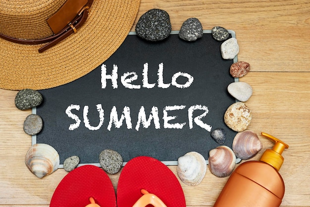 Foto tot ziens of hallo zomer concept zonnecrème en pantoffel met krijtbord en stenen zeeschelp op hout