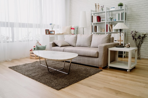 totaaloverzicht van georganiseerde woonkamer met voldoende lichtinval. comfortabel ingerichte salon met goede smaak. houten vloeren en interieurconcept.