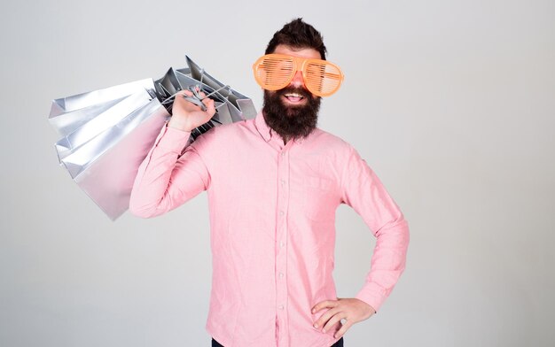 Total sale concept Man bearded hipster with lot shopping bags Shopping on black friday Happy shopping with bunch paper bags Profitable deal Shopping addicted consumer Could not resist discount