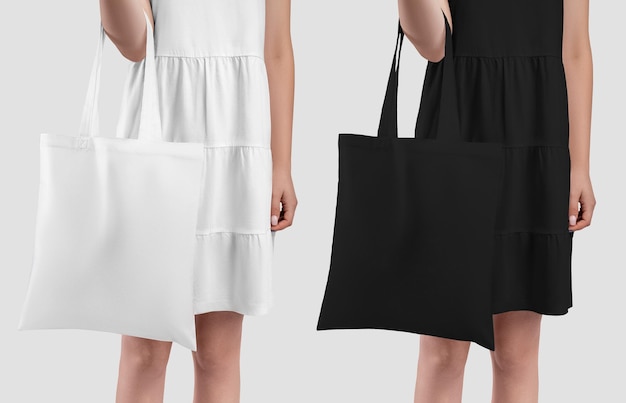 Foto totebag una borsa ecologica bianca nera nelle mani davanti a lei una ragazza in prendisole