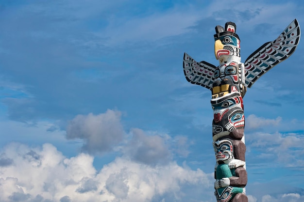 Totem houten paal op de blauwe bewolkte achtergrond