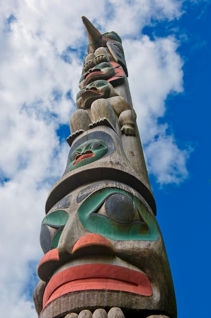 Foto un palo di legno del totem nei precedenti nuvolosi blu