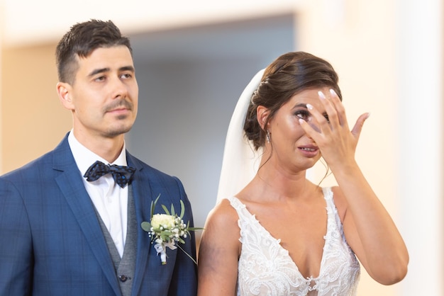 Touching moment of bride\'s tears of joy while standing next to\
her future husband during a wedding