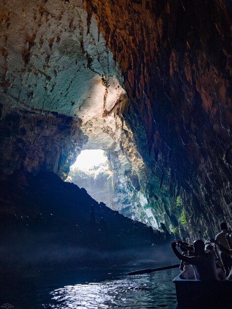 Tour by boat tourists in a cave with an underground lake Melissani on the island of Kefalonia Greece