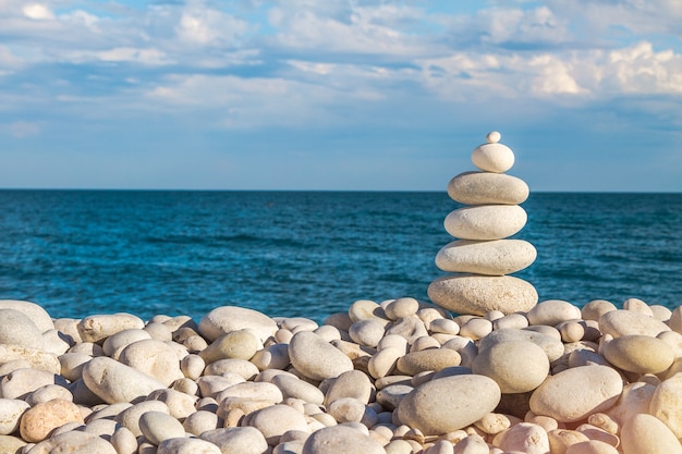 tourette rock zen pyramid of white pebble on the beach