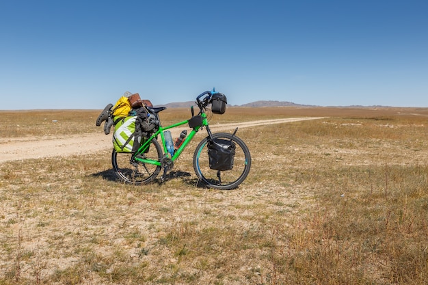 Touring bike full loaded standing on a dirty road tourist bike with bags Mongolian steppe