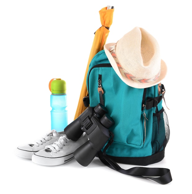 Tourism concept Backpack shoes binocular and hat isolated on white background