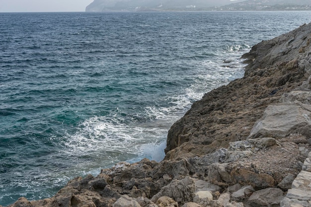 観光、スペイン、イビサ島、マヨルカ島の岩に衝突する地中海。