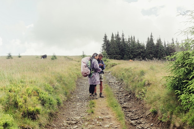 Tourism, mountains, lifestyle, nature, people concept - Group of hikers with backpacks walk along a trail towards a mountain ridge. Backpackers style. Concept of active leisure..