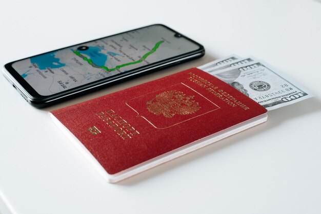 Tourism travel trip journey concept Closeup of an international passport of citizen of Russian Federation money and mobile phone with an online map application Low angle view selective focus