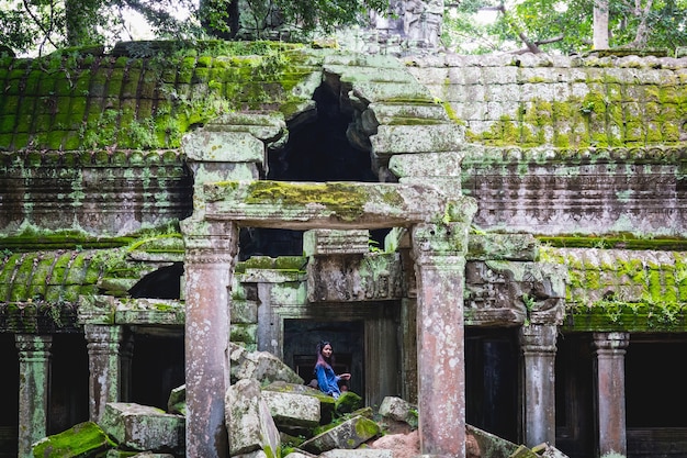 Turista al castello antico stupefacente di bayon del tempio, angkor thom, siem reap, cambogia