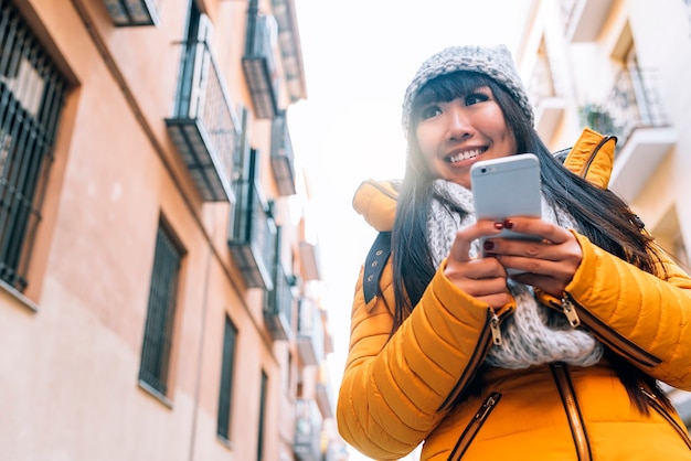 Tourist asian woman using mobile in european street. Tourism Concept.