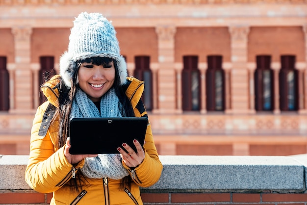 Tourist asian woman using tablet in european street. Tourism Concept.