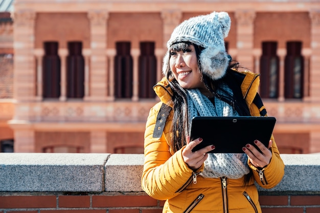 Tourist asian woman using tablet in european street. Tourism Concept.