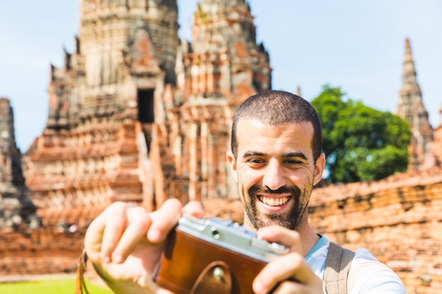 Tourist in Ayutthaya taking a selfie with vintage camera