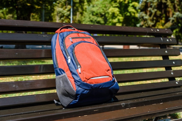 Photo tourist backpack on a bench in city park