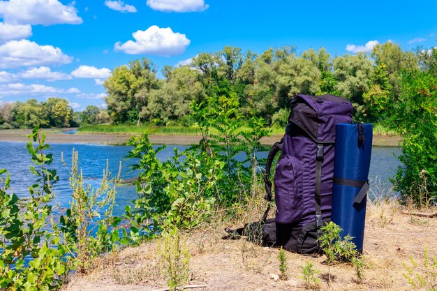 Zaino turistico vicino a un fiume in estate concetto di escursione