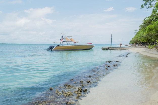 写真 コロンビアのカルタヘナのカリブ海の島のビーチの海岸近くに停泊する観光船