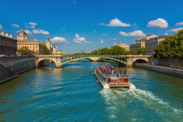 Tourist boat near Conciergerie and bridge Pont NotreDame over river Seine in Paris France