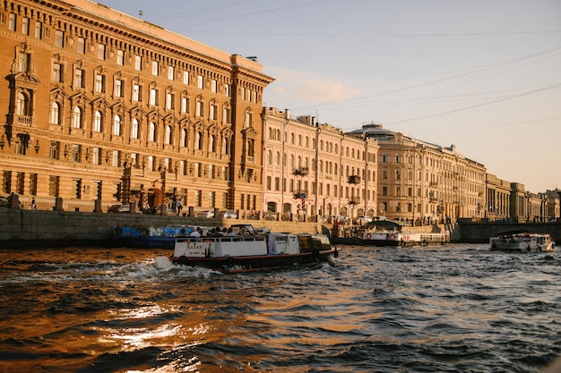 Туристический катер на Зимней канавке Река Нева на закате Санкт-Петербург Россия март 2023