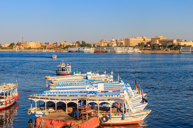 Tourist boats moored near the shore of Nile river in Luxor Egypt