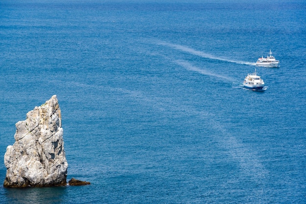 Tourist boats sail past the rock