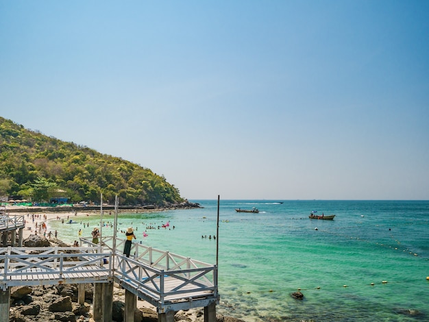 Tourist and boats at tropical beach with turquoise sea