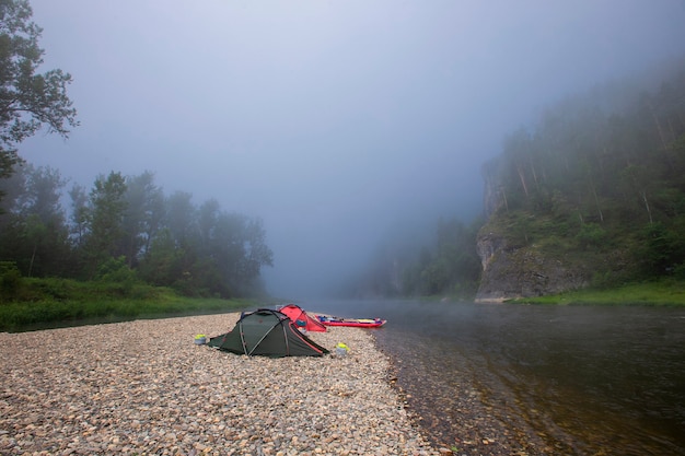 Tourist camp by the river on a foggy morning