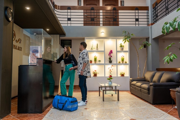 Tourist couple entering the reception of a luxury hotel, in a tourist city.