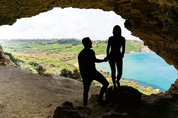 写真 ゴゾ島マルタのタル ミクスタ洞窟で手を繋いでいる観光カップル