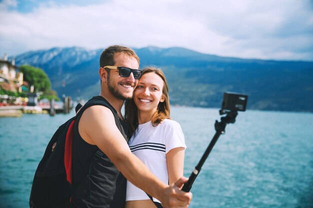 Tourist couple of lovers making selfie photo on motion camera at Lake Garda Italy Europe