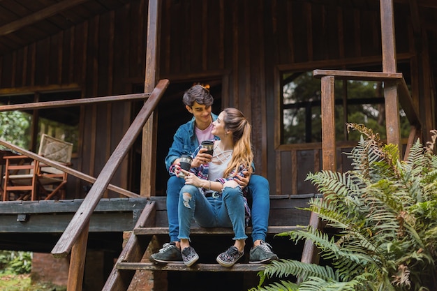 Tourist couple sitting on the stairs drinking coffee