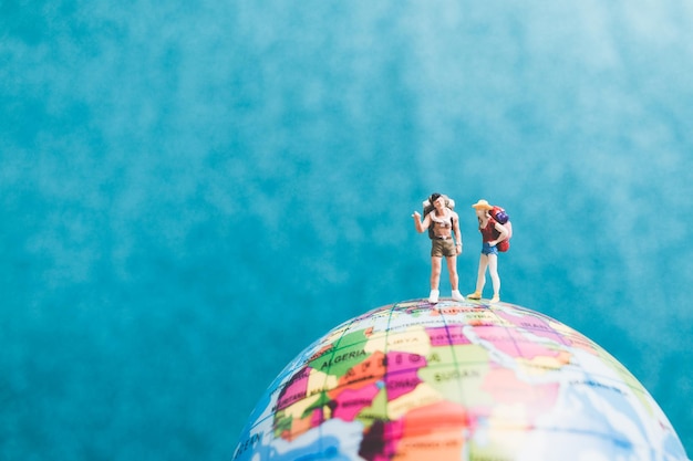 Tourist figurines on globe representing travel