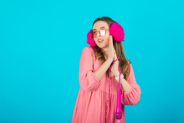 tourist girl in a pink dress in pink headphones with a pink microphone