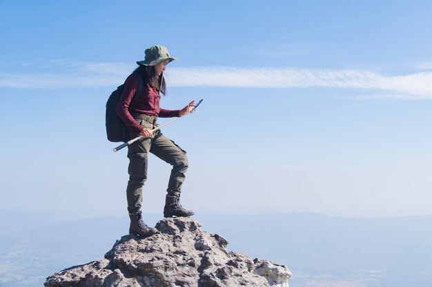 Tourist girl with backpack standing on the stone at the mountain looking panoramic view