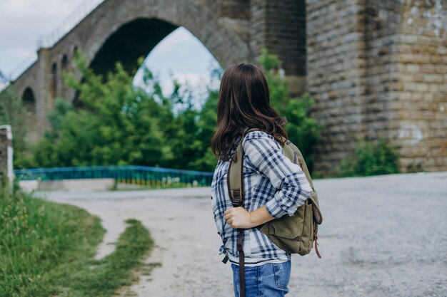 Ragazza turistica con uno zaino sul ponte di pietra.