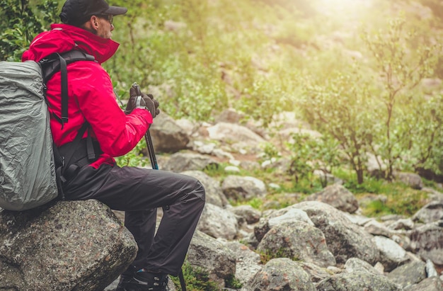 Tourist Hiker Relaxing Seating on a Boulder