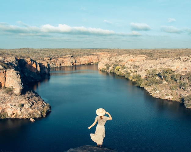 Photo tourist holding hat with dress flying in the canyons of xingo alagoas