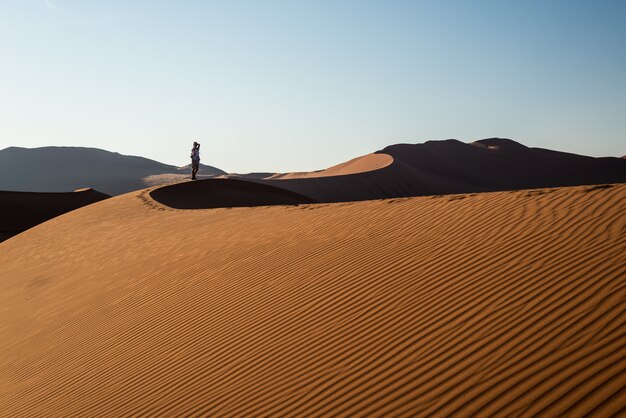 Smart phone turistico della tenuta e scattare foto alle dune di sabbia sceniche a sossusvlei