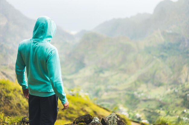 Tourist in hoodie in front of rural landscape in paul valley santo antao island cape verde
