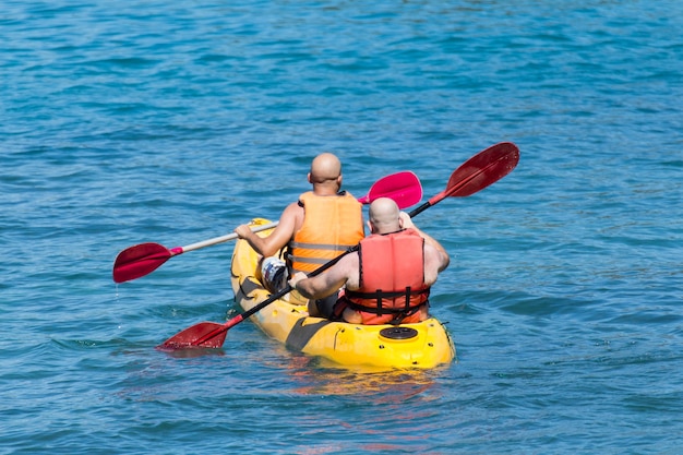 Tourist  kayaking in the Thai ocean from backward view