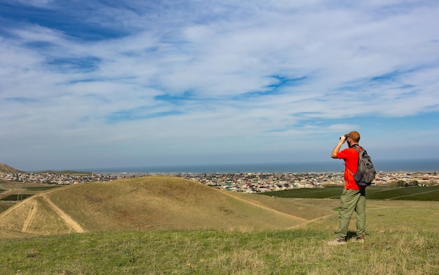 Tourist looking through binoculars at the city