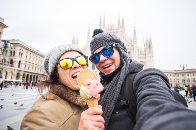 Tourist making selfie photo in front of the famous Duomo cathedral in Milan.