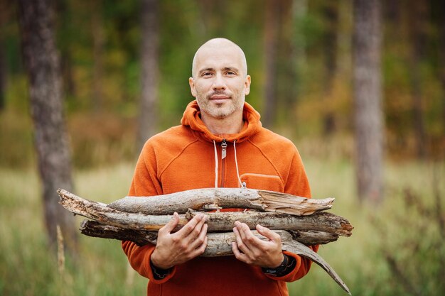 Tourist man gathering wood for a fire