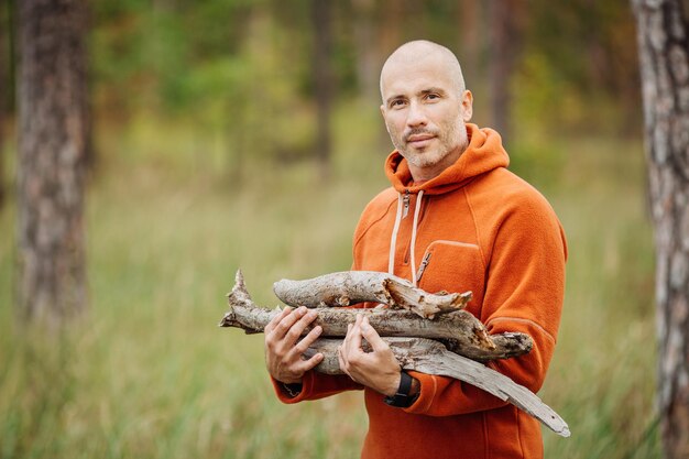 Tourist man gathering wood for a fire